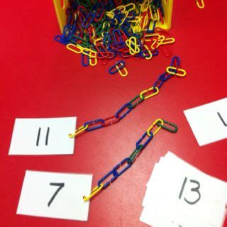 A Red Table Topped With Lots Of Different Colored Paper Clips Next To