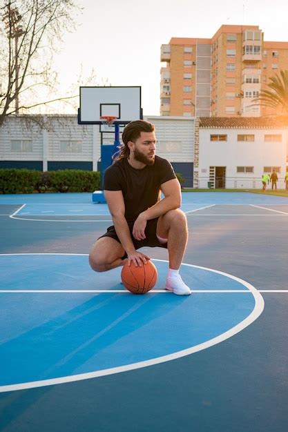 Retrato De Un Hombre Afro Latino Posando Con Una Pelota En Una Cancha