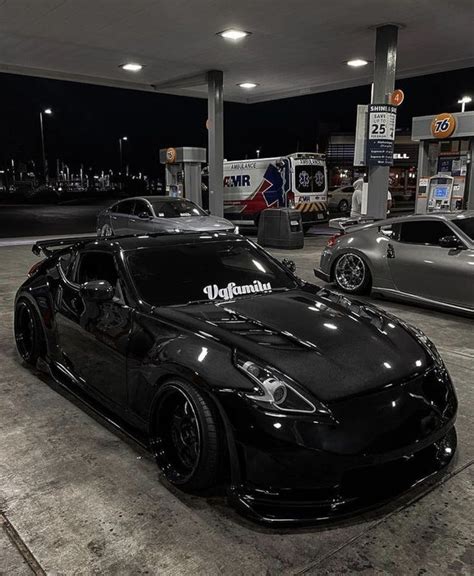 Two Black Sports Cars Parked At A Gas Station