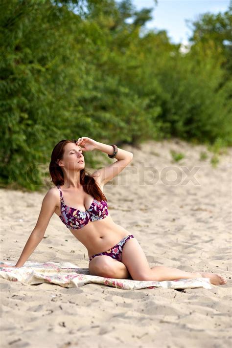 Ung kvinde solbadning på stranden i bikini alene Stock foto Colourbox