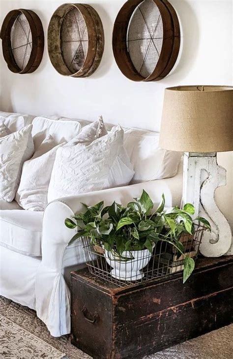 A Living Room With White Furniture And Three Wooden Circles On The Wall