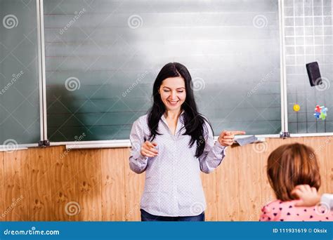 Smiling teacher explains stock image. Image of early - 111931619