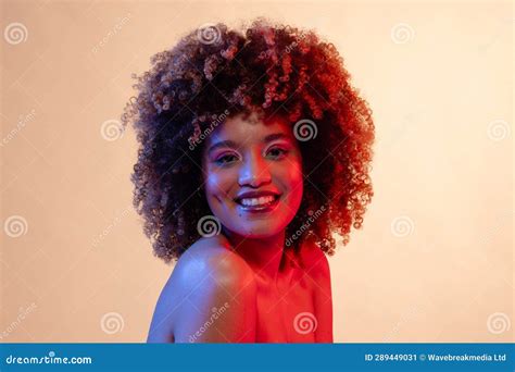 Smiling Biracial Woman With Curly Hair Wearing Pink Eyeshadow And