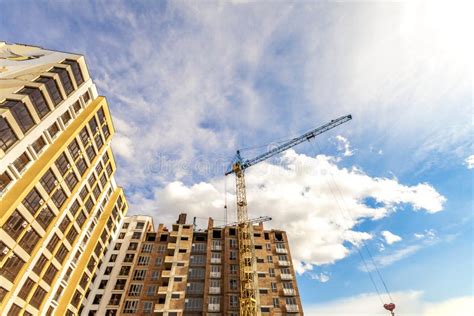 Crane And High Rise Building Under Construction Against Blue Sky Stock