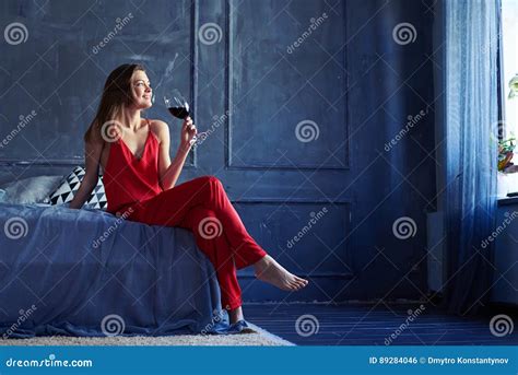 Dreamy Brunette With A Glass Of Wine On The Bed Stock Photo Image Of