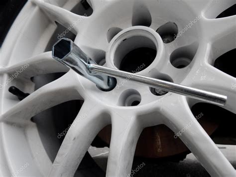 Tubular wrench inside the lug pattern of white car wheel Stock Photo by ...