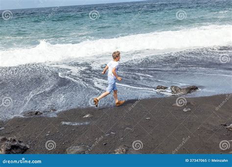 El Muchacho Se Divierte En La Playa Negra Imagen De Archivo Imagen De