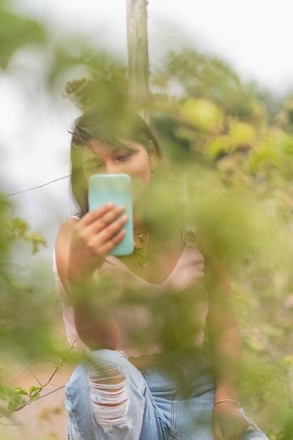 Retrato De Una Joven Latina Usando El Tel Fono M Vil Mientras Se Sienta