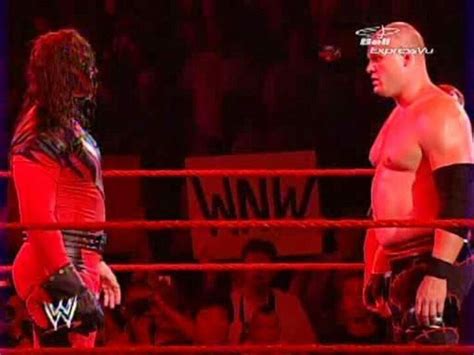two wrestlers standing next to each other in a ring