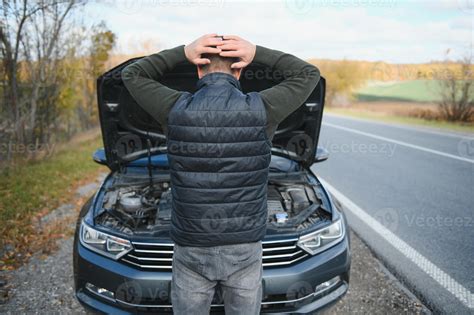 Man repairing a broken car by the road. Man having trouble with his