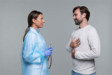 Retrato de mujer llevando bata médica y paciente varón Foto Gratis