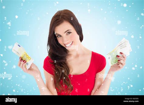 Composite Image Of Cheerful Brunette Holding Her Cash Money Stock Photo