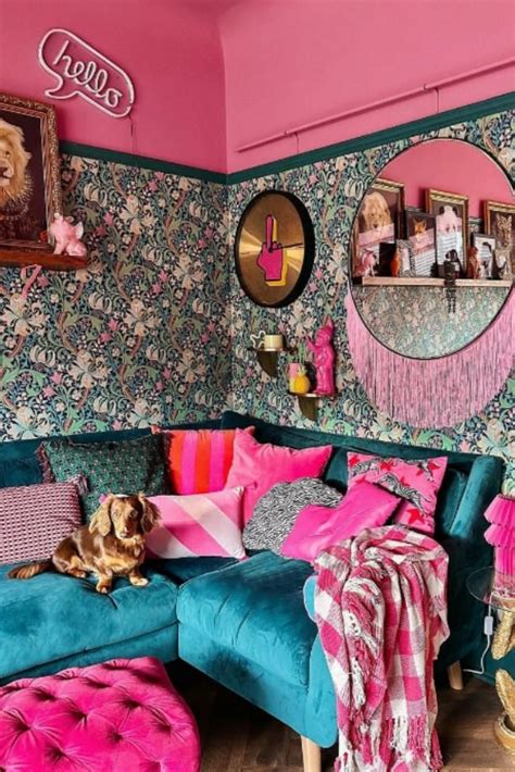 a living room with pink and blue furniture, wallpaper and pictures on ...