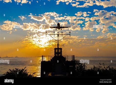 Airplane landing at sunset Stock Photo - Alamy