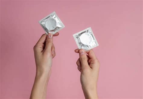 Hands Holding Up Condoms To Ask Can You Have Sex On Your Period And