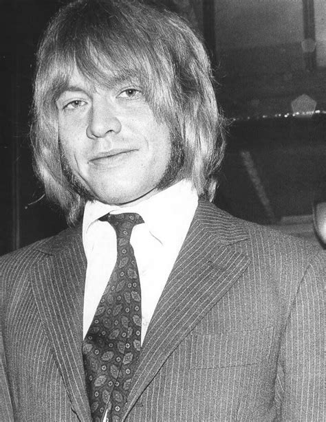 a man with long hair wearing a suit and tie