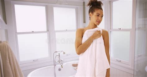 Attractive Black Woman Standing In Bathroom With Towel Covering Nude