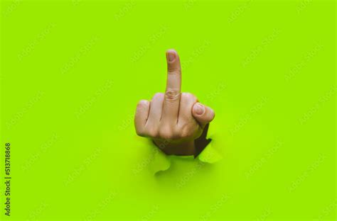 Middle Finger Of Left Hand Insulting Gesture Torn Hole In Green Paper Fuck You Concept