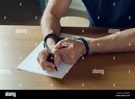 Men Hands With Handcuffs Fill The Police Record Confession On Top Of