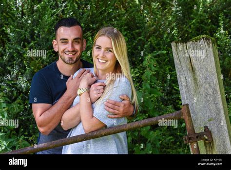 Man Hugging Blonde Girlfriend Beside Iron Gate Stock Photo Alamy
