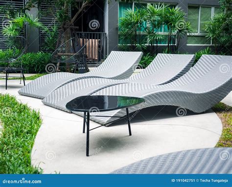 Rattan Wicker Sunbed Near Outdoor Swimming Pool And Green Garden Stock