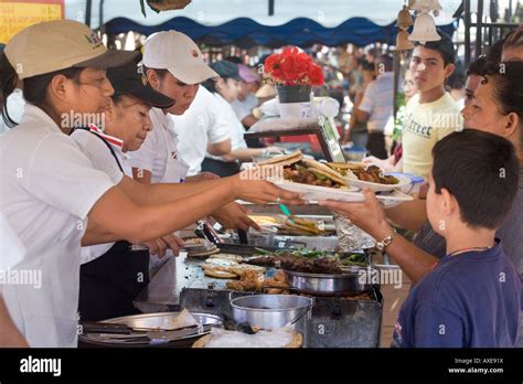 Women cooking for crowds at weekly food festival aka food fair, or