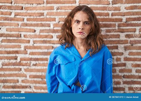 Beautiful Brunette Woman Standing Over Bricks Wall Skeptic And Nervous Frowning Upset Because