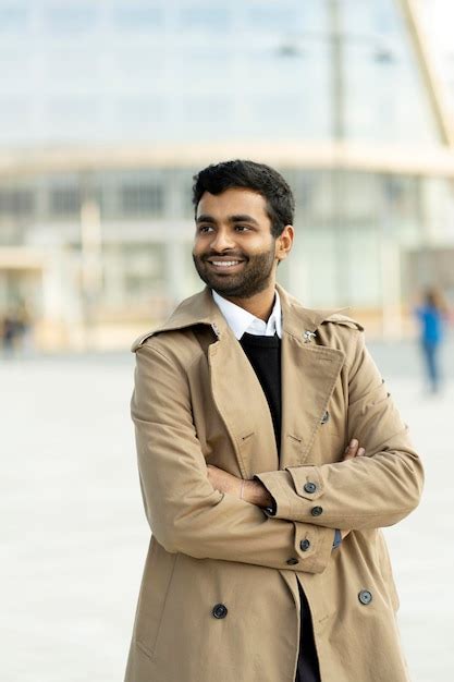 Premium Photo Smiling Indian Man Wearing Stylish Trench Coat With Arms Crossed Looking Away On