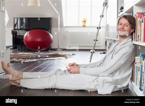 Portrait Of Mature Man Sitting In Front Of Bookshelf Smiling Stock Photo Alamy