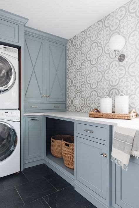 A Washer And Dryer In A Laundry Room With Blue Cabinets White Counter