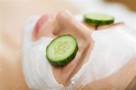 Premium Photo Beautiful Young Woman Receiving Facial Mask Of Cucumber