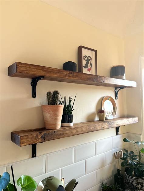 Two Wooden Shelves With Potted Plants On Them