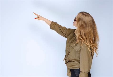 Fille Blonde Pointant Vers Quelqu Un Sur La Gauche Photo Gratuite