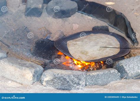 Traditional Arabic Pita Bread Cooking On Fire In Bedouin Dwelling Stock