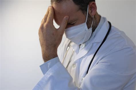 Hombre caucásico vestido con uniforme médico y un estetoscopio sobre