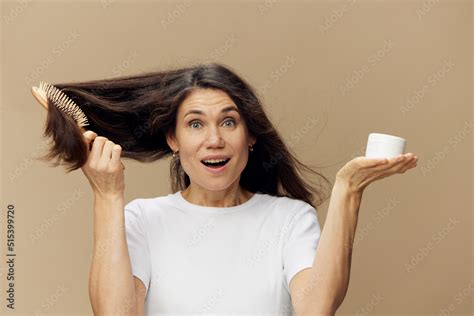 Beautiful Cute Attractive Middle Aged Brunette Combing Her Long Hair With A Wooden Comb While