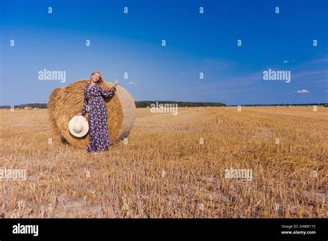 Une Jeune Fille Blonde Aux Cheveux Longs Dans Un Chapeau Blanc Se Repose Et Pose Pr S Des Gerbes