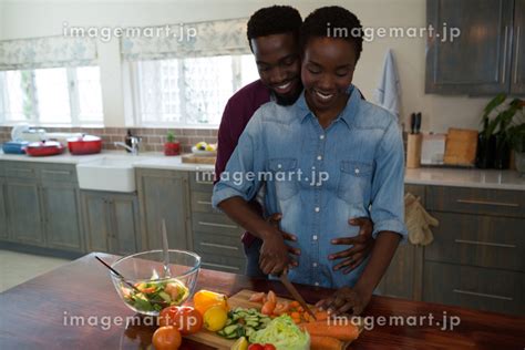 Man touching womans pregnant belly in the kitchenの写真素材 88968191 イメージマート