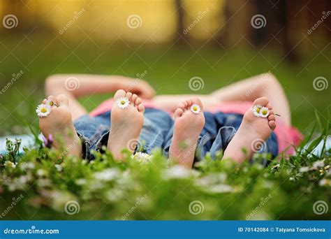 Petits Enfants Heureux Se Situant Dans L Herbe Aux Pieds Nus Aro De