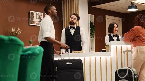 Happy smiling concierge staff team helping tourists with room