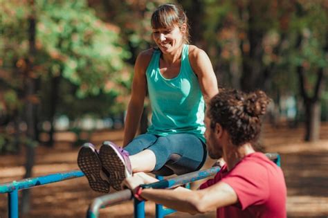 Premium Photo Man Assisting Female Athlete Exercising On Parallel