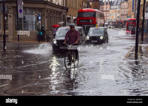 London Uk 17th August 2022 A Cyclist Rides Through A Flooded Kings