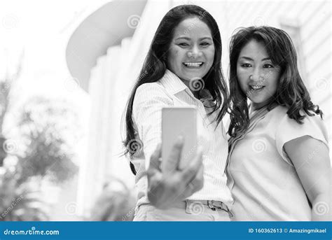 Two Mature Asian Women Taking Selfie With Mobile Phone Stock Image