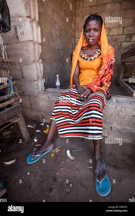 Mozambique A Woman In Colored Traditional Clothes Is Seated Out Of The