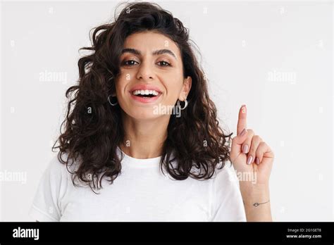 Happy Beautiful Brunette Girl Smiling And Pointing Finger Upward Isolated Over White Background