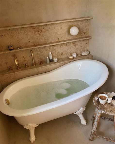 An Old Fashioned Bathtub In The Middle Of A Bathroom