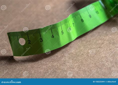 Green Paper Measuring Meter On The Brown Cardboard Measure Tape