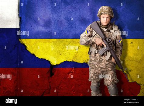 Armed Ukrainian soldier against national flag of Ukraine. Russian