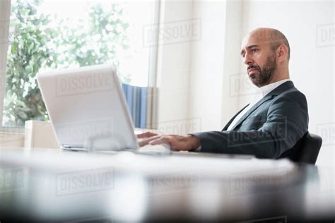 Concentrated Businessman Working With Laptop At Desk In Office Stock