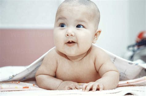 Smiling Baby Lying Naked On Bed Portrait Stock Photo